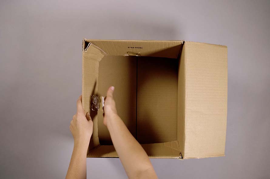 Person opening up a cardboard box